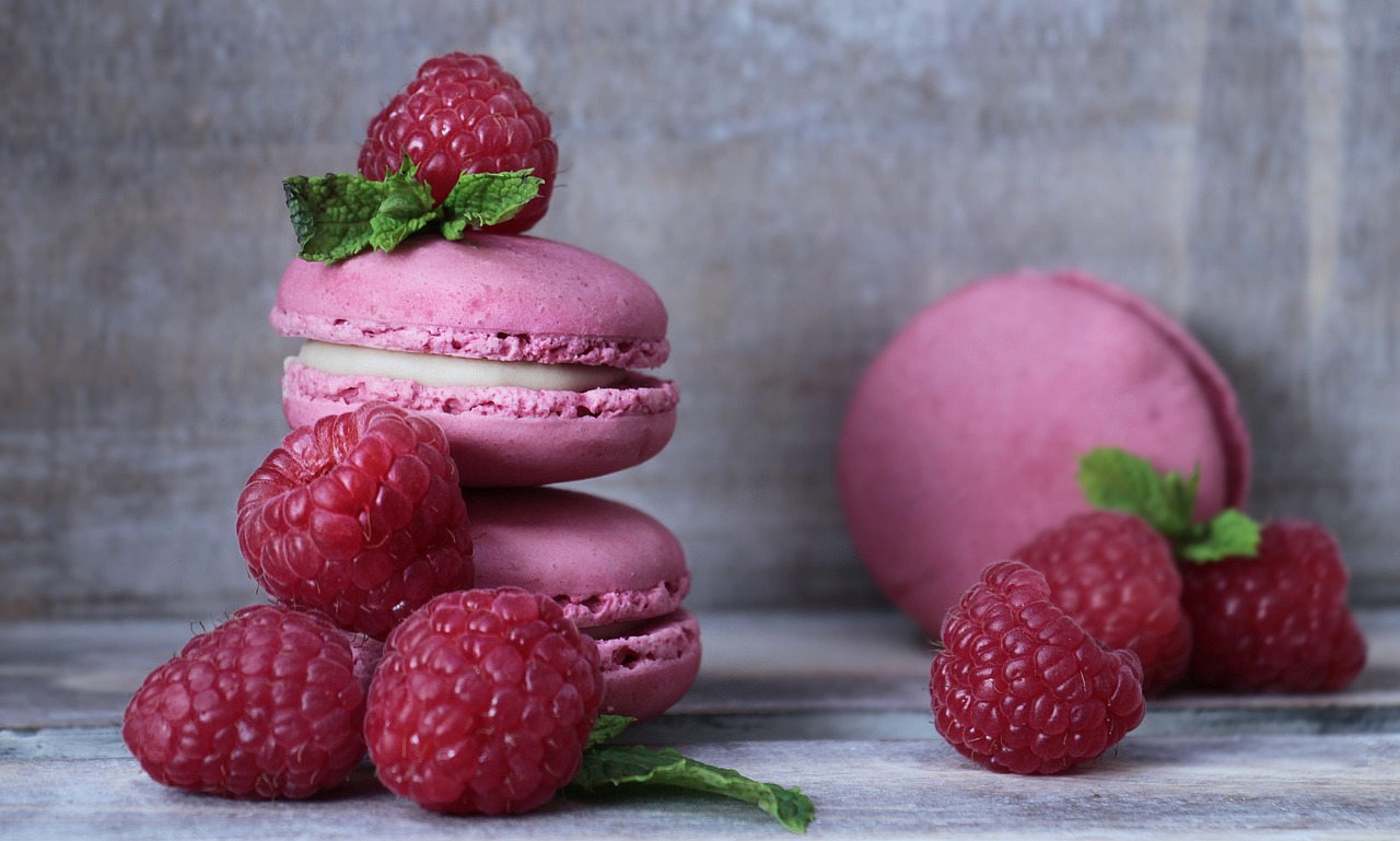 Raspberry macarons stacked with fresh raspberries and mint