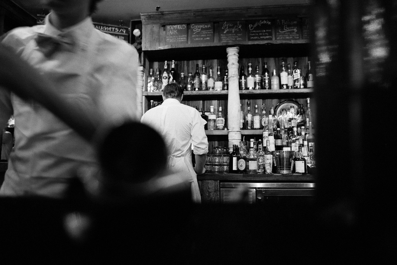 A vintage bar in black and white, bow-tied bartenders at work