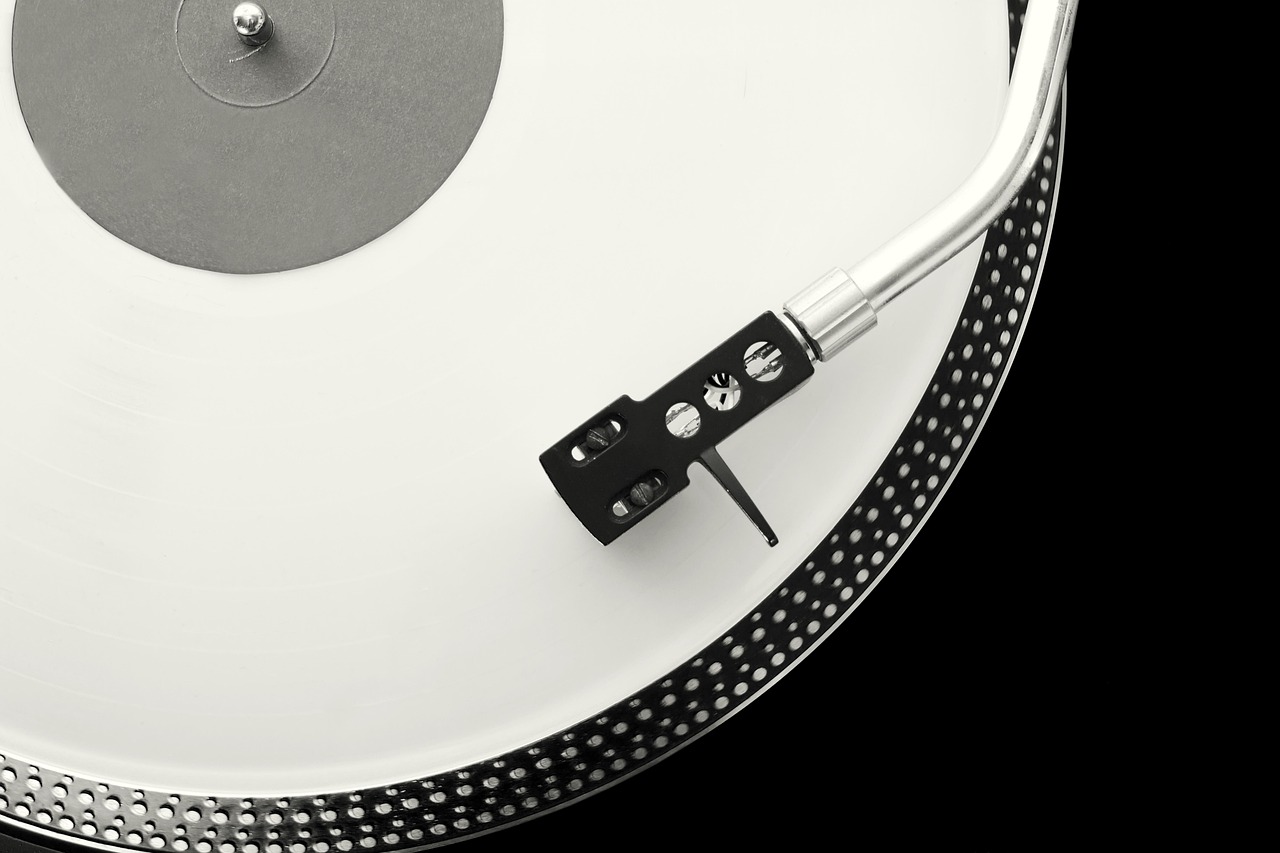 A white vinyl record on a black reference turntable